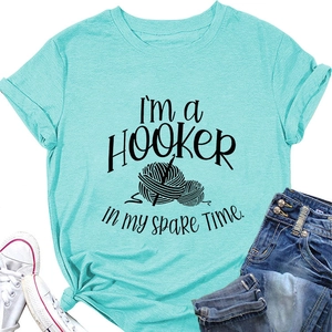 Flat lay of a mint green cotton T-shirt featuring a hooker knitting theme with denim jeans
