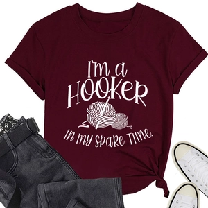 Flat lay of burgundy cotton T-shirt with crochet hooker slogan, jeans and sneakers