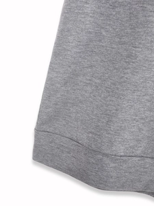 Détail de l'ourlet du sweat-shirt en maille gris chiné avec surpiqûres fines à plat