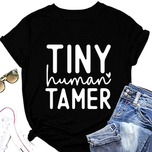Flat lay of black Tiny Human Tamer cotton T-shirt with casual shorts and accessories