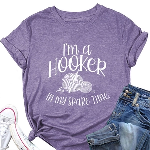 Flat lay of purple short sleeve t-shirt with hooker crochet print and denim jeans