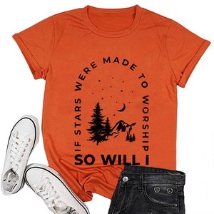 Flat lay of an orange cotton T-shirt featuring a mountain star graphic with white sneakers