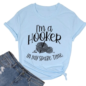Detail of light blue cotton T-shirt featuring crochet text art and bottom hem knot detail