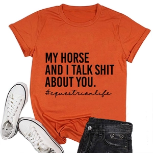 Orangefarbenes T-Shirt mit Reiter-Slogan, Jeans-Shorts und weißen Segeltuchschuhen
