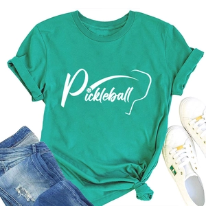 T-shirt Pickleball verde brillante con maniche arrotolate e jeans blu su piano
