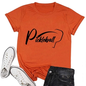 T-shirt arancione Pickleball distesa con scarpe alte e pantaloncini in denim
