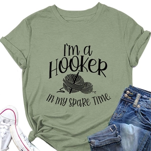 Close-up of green cotton T-shirt with I'm a HOOKER humor print and knitting graphic