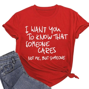 Dettaglio di una t-shirt rossa a girocollo con stampa bianca e nodo decorativo sull'orlo