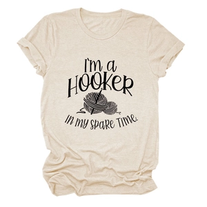 Detail showing the 'I'm a Hooker' slogan and crochet illustration on oat-colored tee