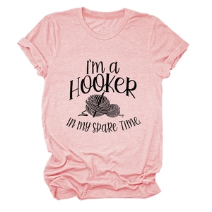 Detail of pink cotton T-shirt featuring funny crochet hooker print and knitting graphics