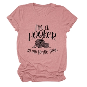 Detail of pink cotton T-shirt featuring 'I'M A HOOKER' graphic with crochet yarn patterns