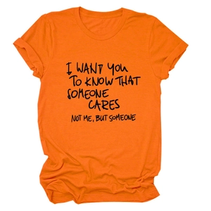 Dettaglio della t-shirt in cotone arancione con stampa slogan nera e girocollo classico