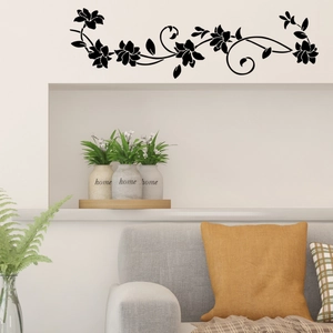 Detail view of black floral vine wall stickers in a cozy living room with grey sofa