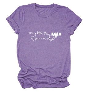 Detail of purple T-shirt showing the bird illustration and cursive inspirational text