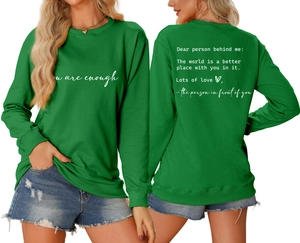 Close-up of grass green crewneck sweatshirt with 'You are enough' text and rib-knit cuffs