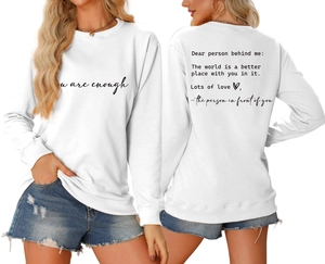 Detailed view of white sweatshirt featuring 'you are enough' print on front and back