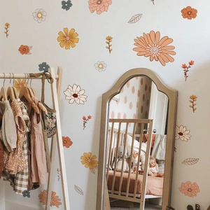 Detail of bohemian daisy floral wall decals in a cozy nursery room with an arched mirror