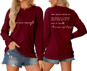 Detail of burgundy crewneck sweatshirt featuring white you are enough graphic print