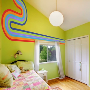 Detailed close-up of rainbow wave wall stickers in a cozy green bedroom setting