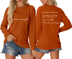 Detail of caramel crewneck sweatshirt with 'you are enough' front print and back text