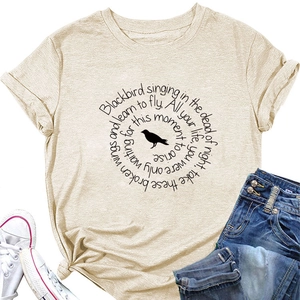 Flat lay of apricot short sleeve t-shirt with blackbird print and lyric typography detail