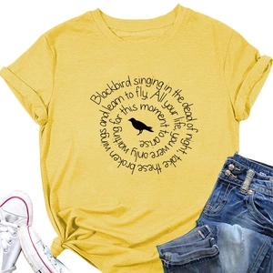 Detail of yellow cotton t-shirt featuring blackbird print and knot design at the hem
