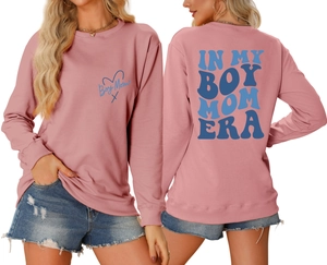 Detail of dusty pink sweatshirt with blue Boy Mom Era typography on front and back