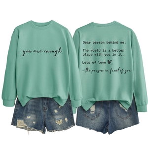 Front and back detail of a mint green sweatshirt with You are enough text and denim shorts