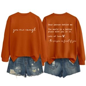 Detailed back view of orange crewneck sweatshirt with inspirational quote print