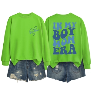 Flat lay of Boy Mom sweatshirt with back graphic and ripped denim shorts set