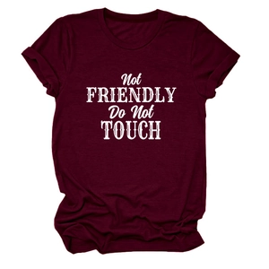 Detail of burgundy T-shirt showing Not Friendly Do Not Touch print and rolled sleeves