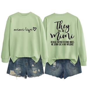 Dettaglio della felpa verde menta con stampa Mimi Life e pantaloncini di jeans
