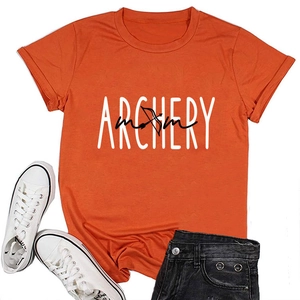 Flat lay of an orange Archery Mom T-shirt styled with denim shorts and white sneakers