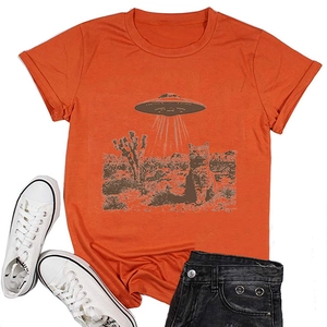 Flat lay of bright orange cotton T-shirt featuring a vintage cat and UFO graphic print