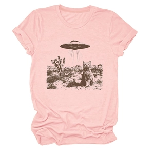 Close-up of pink cotton T-shirt featuring a surreal cat and UFO desert landscape print