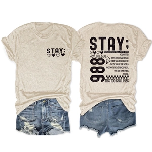 Detail van voor- en achterkant van haverkleurig T-shirt met STAY-print en citaten