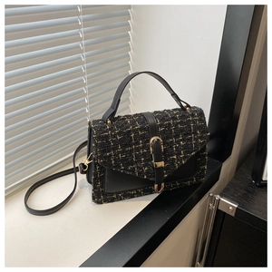 Detail of tweed crossbody bag with gold hardware and elegant rectangular structure
