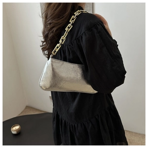 Detail of silver metallic textured underarm bag with industrial chain strap