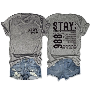 Detail van grijs t-shirt met tekst en distressed denim shorts in een setje