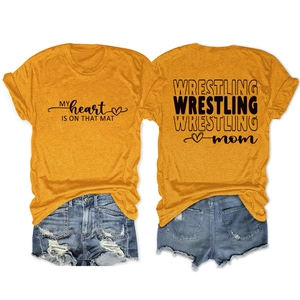 Flat lay of wrestling mom mustard t-shirt and distressed denim shorts casual summer set