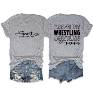 Flat lay of gray Wrestling Mom t-shirt paired with distressed denim shorts on white background