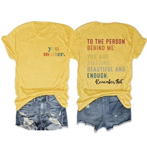 Detail view of ginger yellow cotton T-shirt with motivational back print and denim shorts