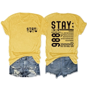 Detailopname van geel T-shirt met teksten en distressed denim korte broek setje