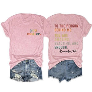 Macro shot of pink cotton T-shirt featuring 'you matter' text and denim shorts