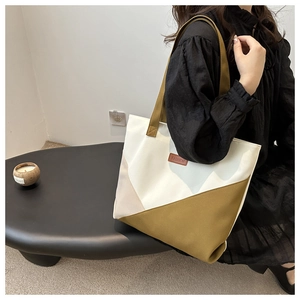 Close-up of geometric canvas tote bag with fashion leather patch and large capacity detail