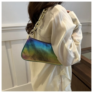 Detail of gradient metallic leather texture and chunky gold chain strap on the handbag