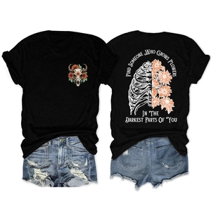 Flat lay of black crewneck T-shirt with sunflower skull print and denim shorts