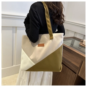 Detail of color-block canvas tote bag with olive green and beige panels for women