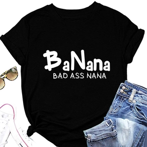 Flat lay of black BAD ASS NANA t-shirt with denim shorts, sneakers and sunglasses