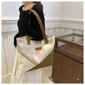 Detail of spacious geometric patchwork tote bag in beige and olive green colors
